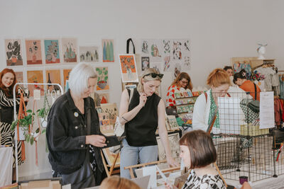 Visitors browse contemporary prints at the market