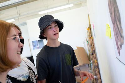 Young people looking at artwork on the wall