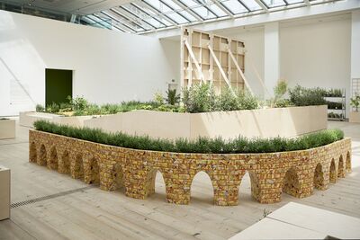 A curved brick wall in the gallery is a plant pot for grass-like plants.