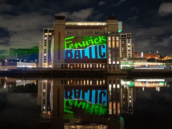 Baltic lit up with a big green and blue projection of Fenwick and Baltic's logos.